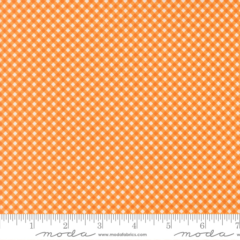 Orange and white gingham fabric pattern shown flat with a measuring ruler along the bottom edge for scale.