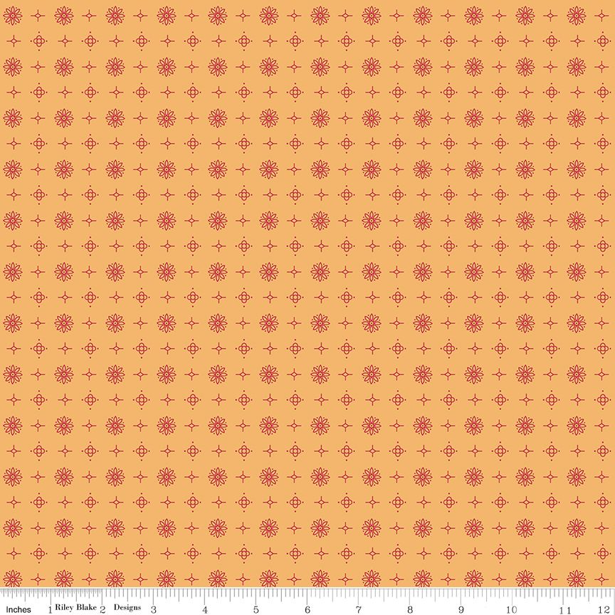 A repeating fabric pattern featuring small red floral medallions interspersed with red plus-sign motifs on a warm gold background. A ruler scale is visible along the bottom edge.