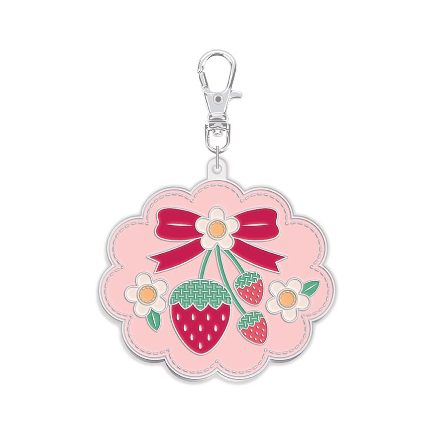 Keychain with pink floral design, strawberries, and a bow on a white background