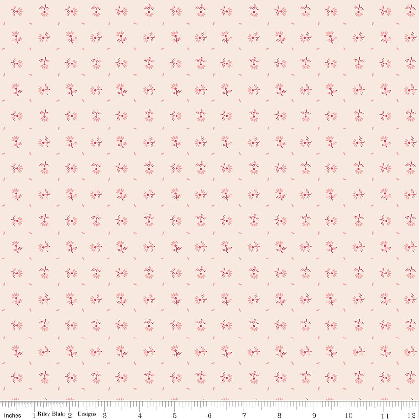 A repeating fabric pattern featuring small pink floral motifs and tiny pink dash marks on a pale blush pink background, with a ruler along the bottom edge showing scale.