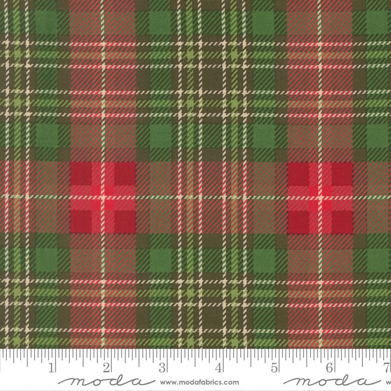A close-up of a plaid fabric pattern with green, red, brown, and beige stripes, featuring a white ruler at the bottom with Moda Fabrics branding.