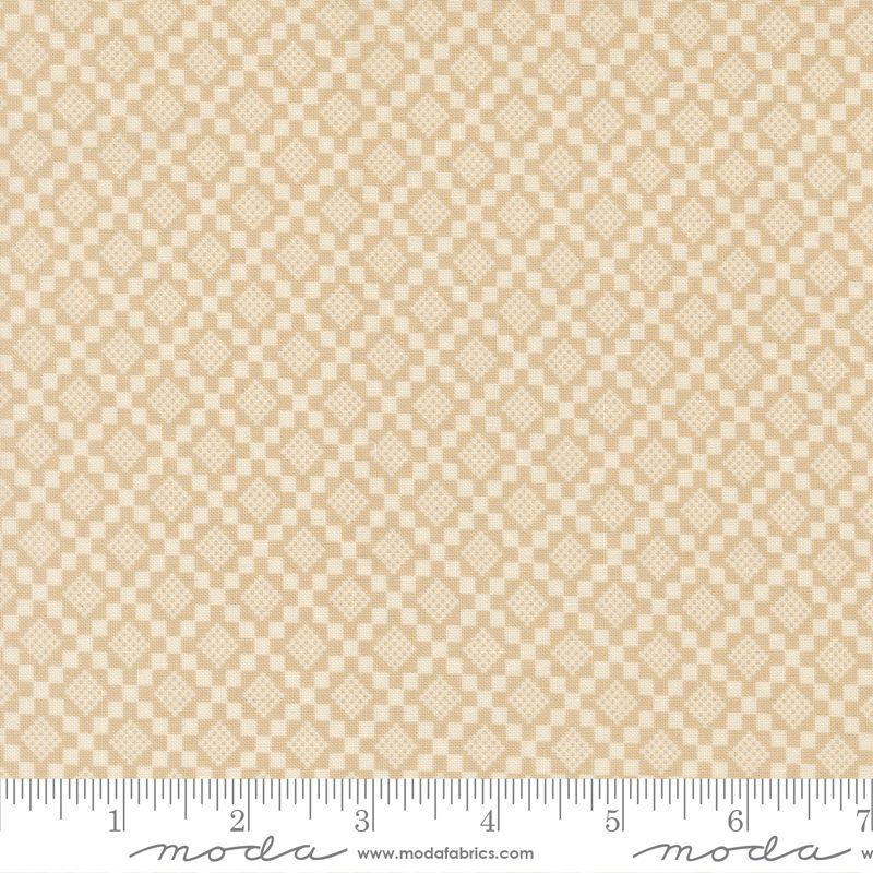 Beige and cream checkered fabric with repeating diamond motifs, shown flat with a measuring ruler along the bottom edge.