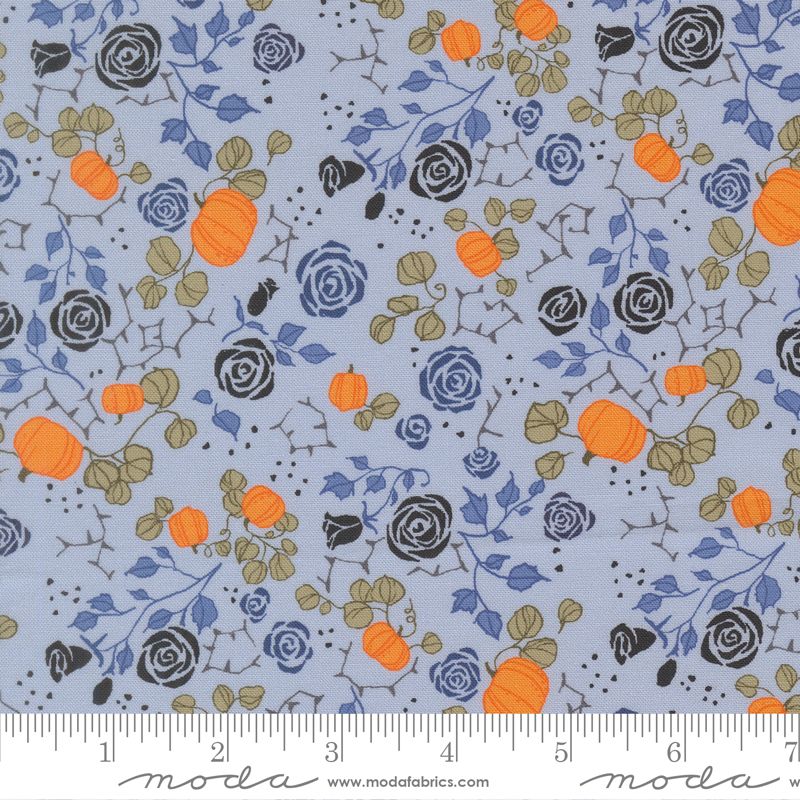 Fabric pattern with pumpkins and flowers on a blue background, featuring Moda label.