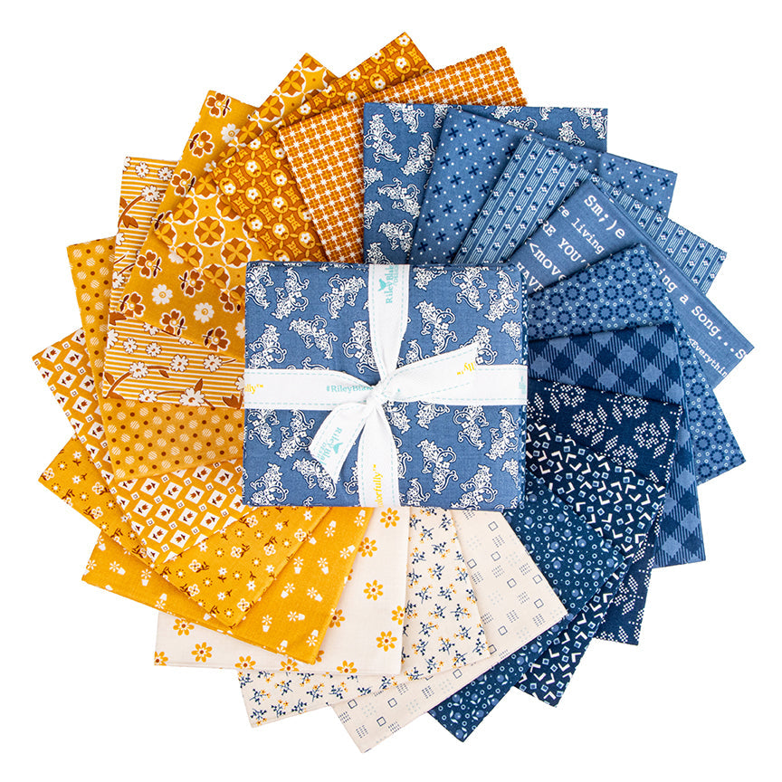 Denim & Daisy by Lori Holt fat quarter bundle showing blue and yellow floral and geometric quilting fabrics