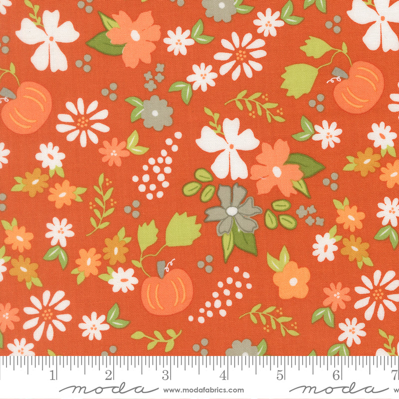 Fabric swatch with a warm orange background print featuring orange, white, and gray flowers with orange pumpkins, green leaves, and white and gray dots.