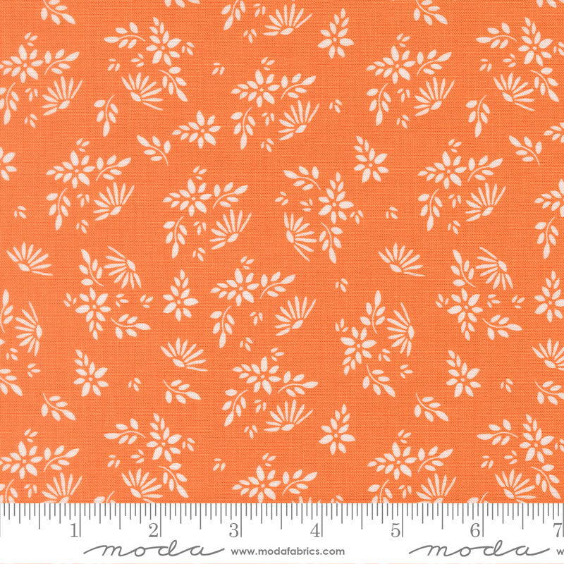 Fabric with a bright orange background with scattered white flowers and leaves. 