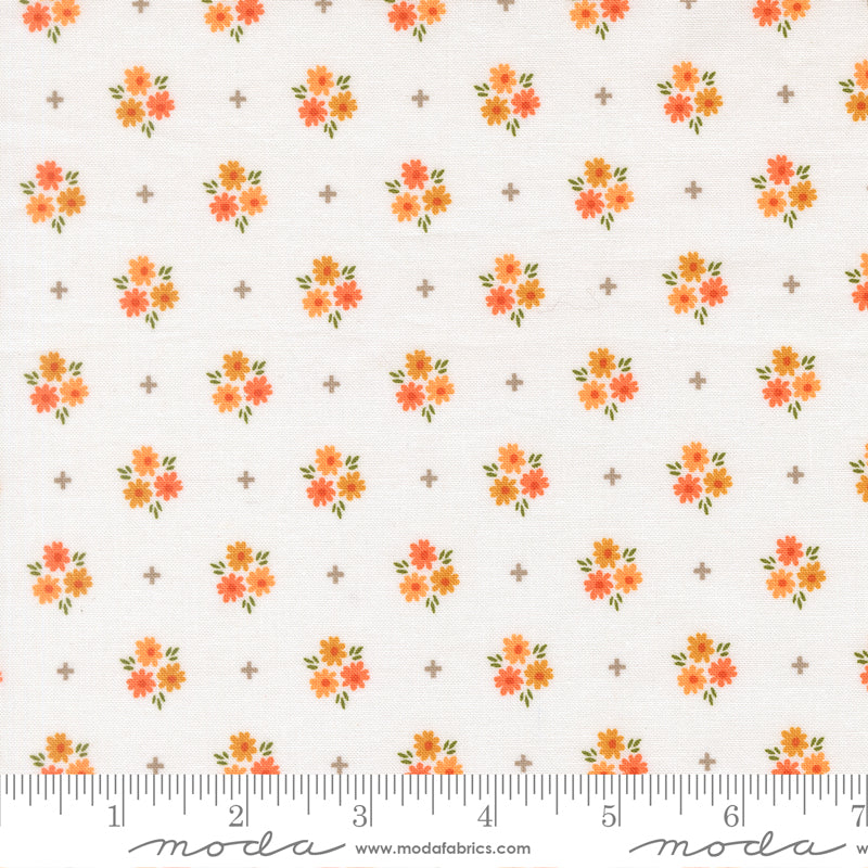 Fabric with a crisp white background print featuring orange flowers and gray plus signs.  Ruler at bottom to show scale.