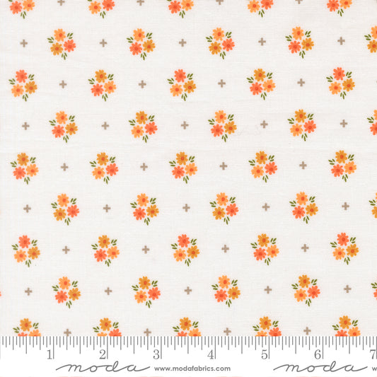 Fabric with a crisp white background print featuring orange flowers and gray plus signs.  Ruler at bottom to show scale.