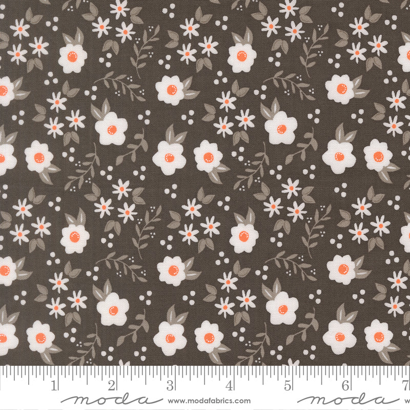 Fabric swatch with a charcoal background with orange and white flowers with light gray foliage and white dots.