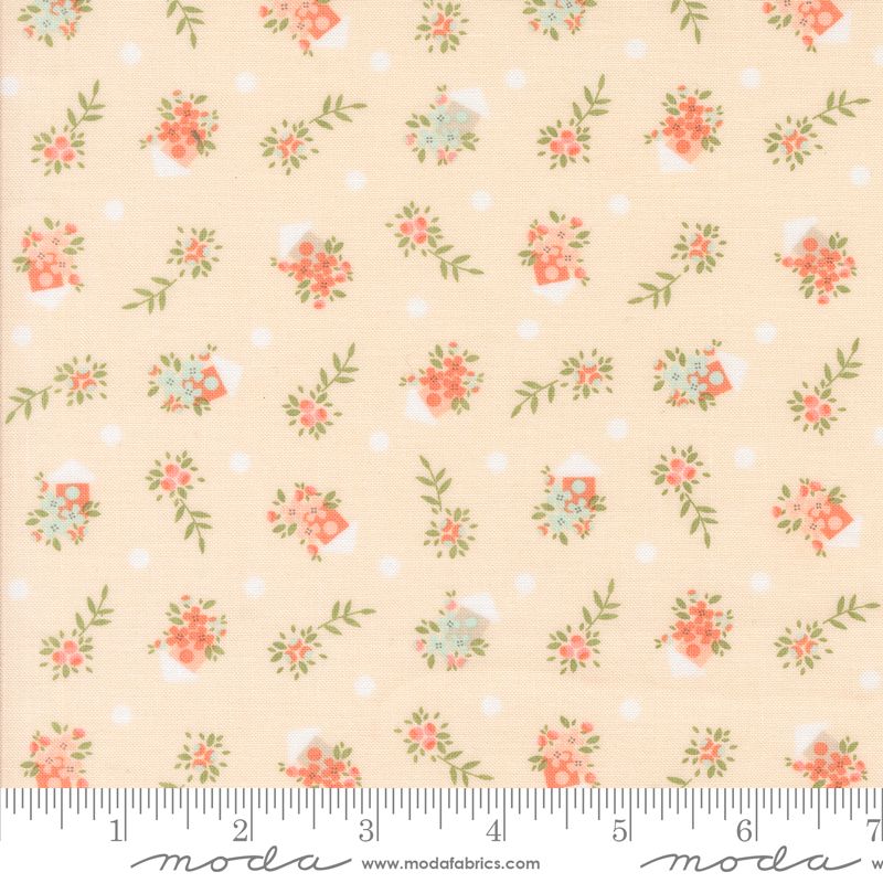 A repeating fabric pattern on a pale peach background with small white polka dots, floral bouquets in coral and pale blue, green leaves, and tiny bird houses. A measuring ruler is visible along the bottom edge, and the word 'moda' appears at the bottom.