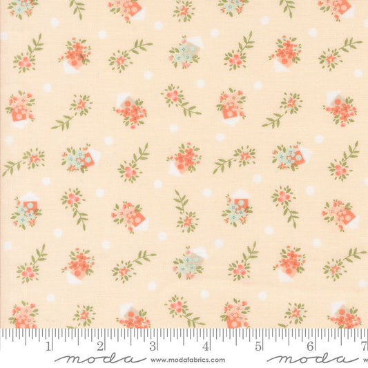 A repeating fabric pattern on a pale peach background with small white polka dots, floral bouquets in coral and pale blue, green leaves, and tiny bird houses. A measuring ruler is visible along the bottom edge, and the word 'moda' appears at the bottom.