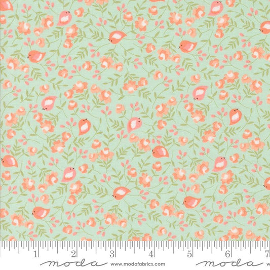A repeating fabric pattern featuring small pink birds, coral flowers, and green leaves on a pale pale blue background, with a ruler and Modas Fabrics branding along the bottom edge.