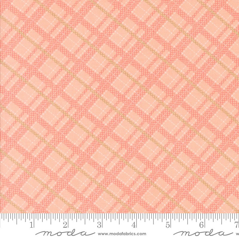 A close-up of a fabric pattern swatch featuring a repeating geometric diamond grid design in coral pink and light peach, with a white ruler along the bottom edge showing measurements. The brand name 'modafabrics' is visible on the ruler.