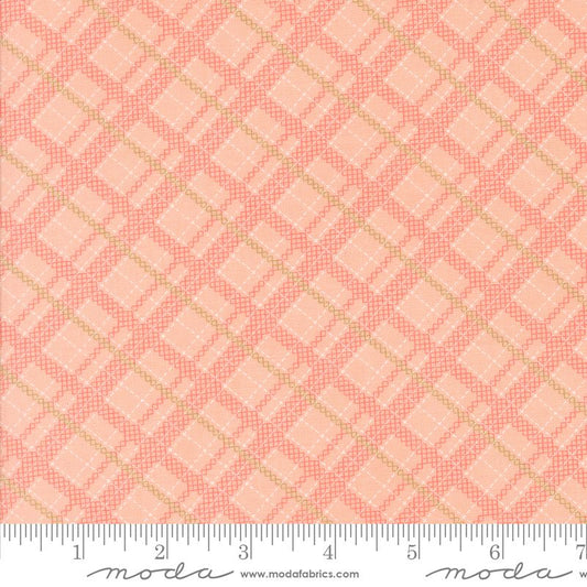 A close-up of a fabric pattern swatch featuring a repeating geometric diamond grid design in coral pink and light peach, with a white ruler along the bottom edge showing measurements. The brand name 'modafabrics' is visible on the ruler.