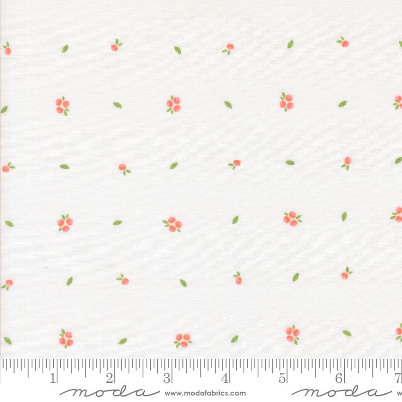 White fabric with a repeating pattern of small pink flowers with green leaves and stems, shown with a measuring ruler along the bottom edge.