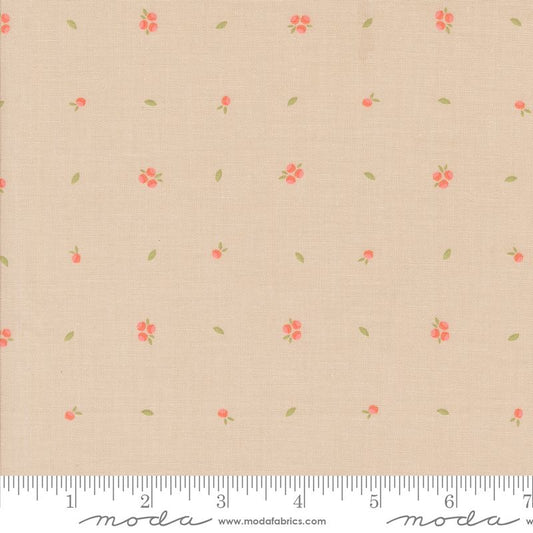 Beige fabric with a small-scale repeating pattern of coral-red flowers and green leaves, shown with a measuring ruler along the bottom edge.