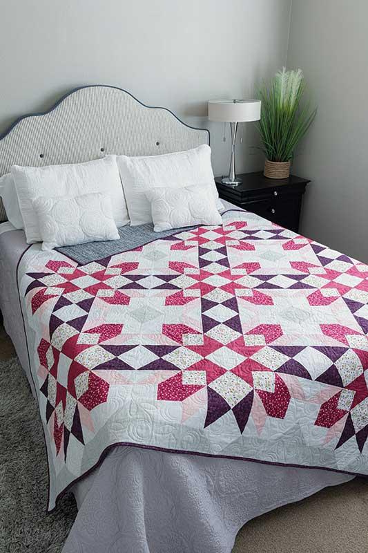 Quilt with geometric pattern on a bed in a bedroom setting