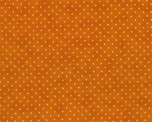 A close-up of orange fabric with a repeating pattern of small white polka dots.