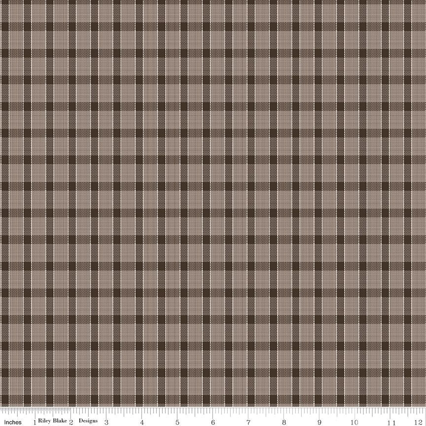 A black and beige plaid fabric pattern shown flat, with a ruler along the bottom edge for scale. The pattern consists of intersecting brown and beige grid lines forming a plaid design.