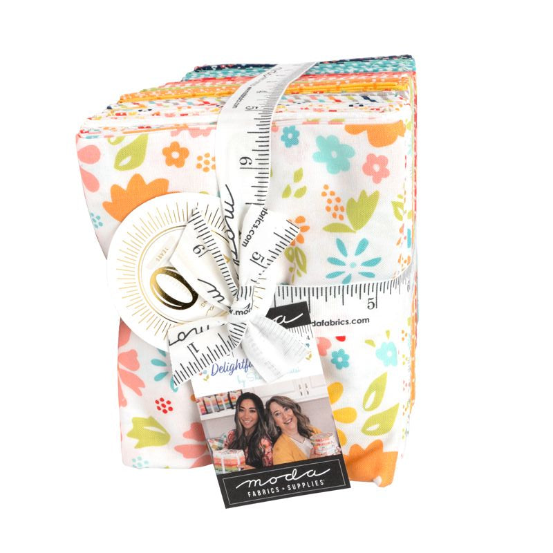 A bundle of fabric cutups wrapped with a white measuring tape and ribbon, featuring a floral pattern on a white background. A black tag on the right reads 'Madly Mini Mart'.