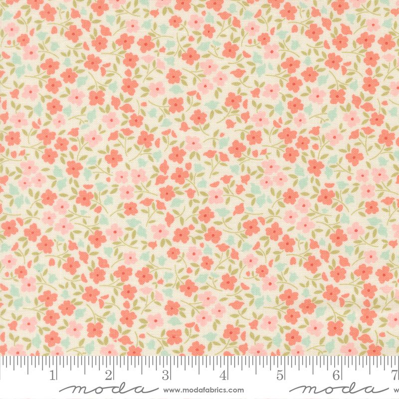 A close-up of a fabric pattern featuring small pink and coral-red flowers with green leaves on a cream background, with a measuring ruler along the bottom edge showing the scale.