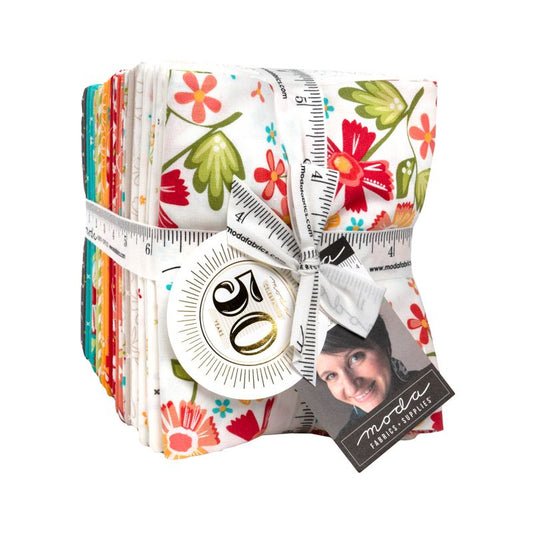 A bundle of Moda Fabrics 20-piece quilting cotton set, featuring a white background with a vibrant multicolor floral pattern. The bundle is wrapped with a white measuring tape strap, a round white paper tag, and a black brand card showing a smiling portrait.