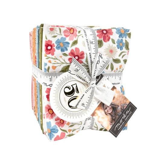 A stack of floral-patterned fabric pieces tied with a white measuring ribbon and tape measure, with a brand tag attached, on a plain white background.