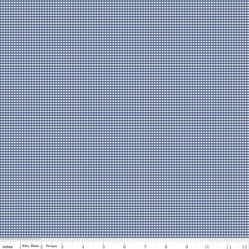 A close-up fabric pattern swatch showing a small-scale blue and white gingham or checkered grid, with a small printed ruler strip along the bottom edge indicating scale.