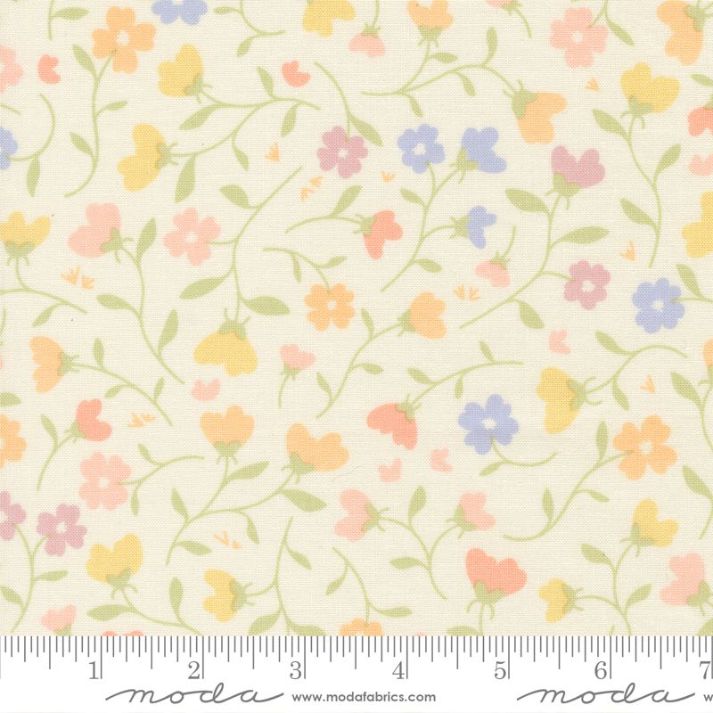 A close-up of a fabric pattern featuring small pastel flowers in pink, yellow, orange, and blue on a cream background, with a ruler along the bottom edge showing measurements and Moda Fabrics branding.