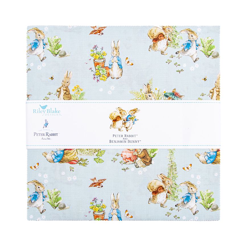A fabric layer cake with a Peter Rabbit and Benjamin Bunny design on a light blue background