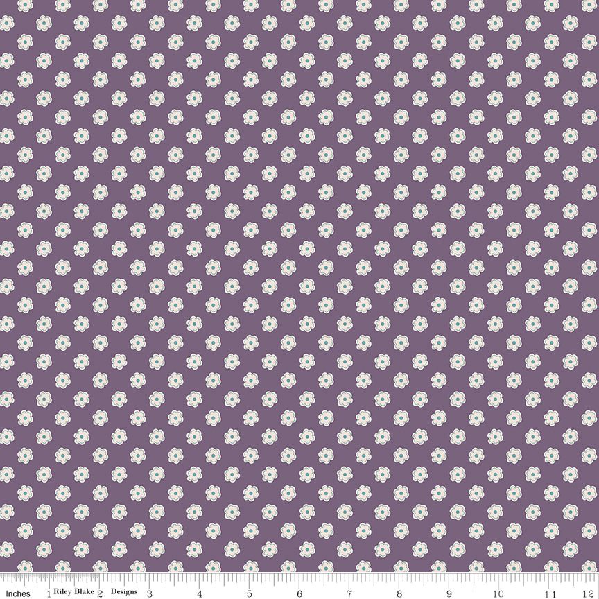 Purple fabric with a repeating pattern of small white flowers, shown flat with a measuring ruler along the bottom edge.
