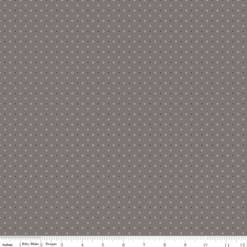 A close-up fabric or material swatch showing a repeating small white diamond pattern on a medium gray background, with a ruler along the bottom edge for scale.