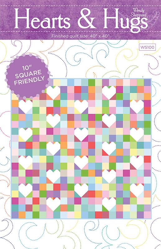 Front cover of a quilting pattern booklet titled 'Hearts & Hugs' by Windy Sheppard. The cover shows a finished quilt with a multicolor patchwork background and rows of white hearts, plus text noting a finished size of 40" x 40" and 10" square friendliness.