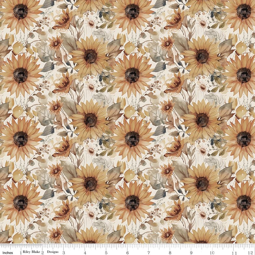 A repeating floral pattern featuring large sunflowers and smaller wildflowers in warm tan, brown, olive green, and cream tones on an off-white background, with a ruler along the bottom edge showing scale.