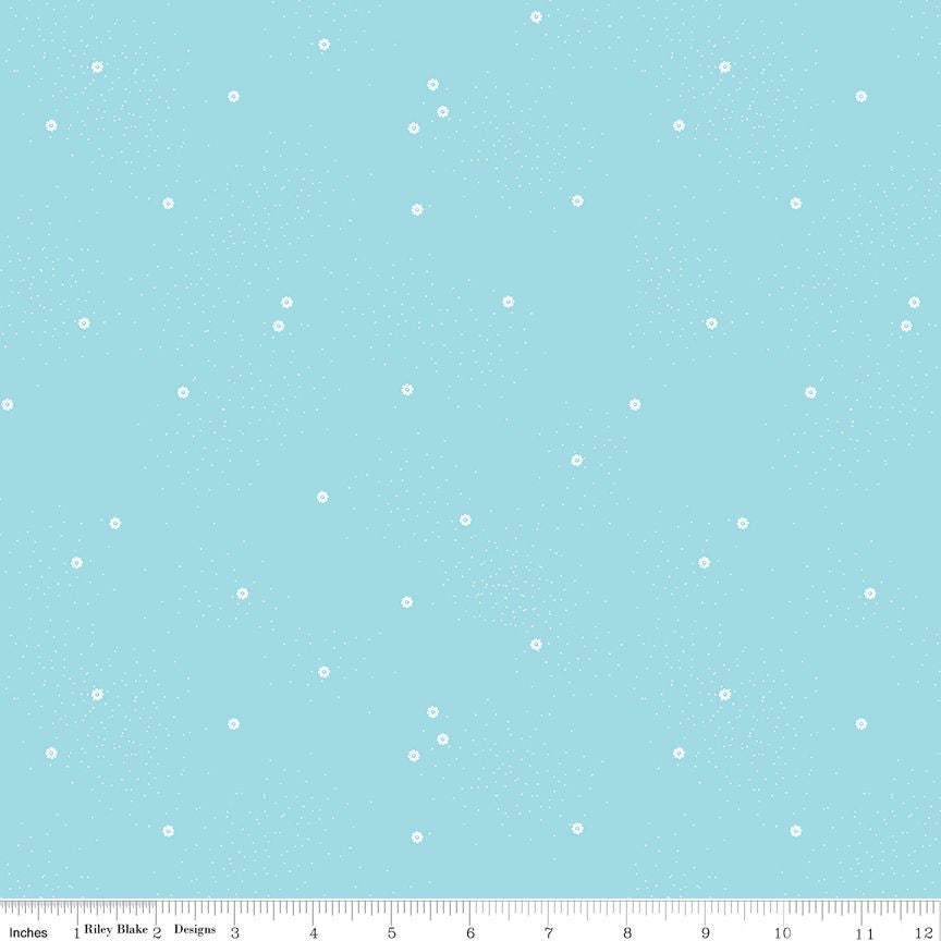 Light blue fabric with a scattered pattern of small white daisies and tiny speckles, shown with a ruler along the bottom edge.