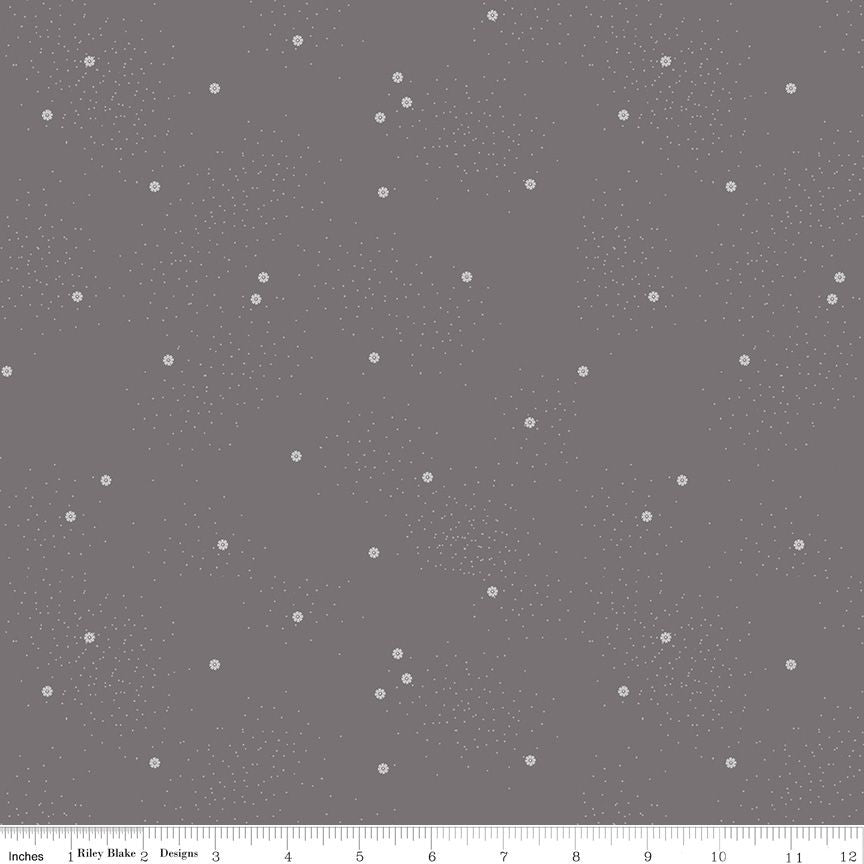 A fabric pattern swatch showing a medium gray background with a scattered print of small white daisies and tiny speckles, with a ruler at the bottom indicating scale.