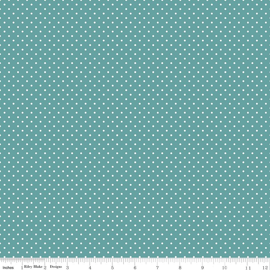 A repeating pattern of small white dots on a teal fabric background, with a ruler along the bottom edge showing measurements in inches.