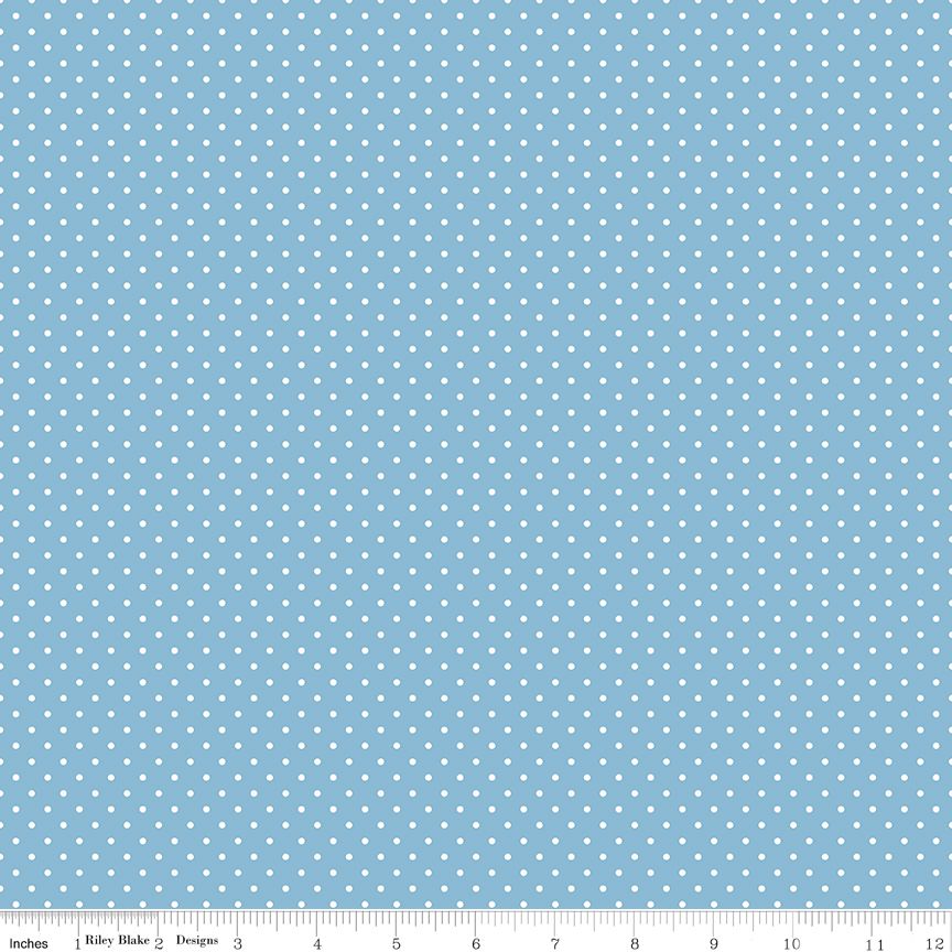 Light blue fabric with a repeating pattern of small white dots, shown flat with a measuring ruler along the bottom edge.