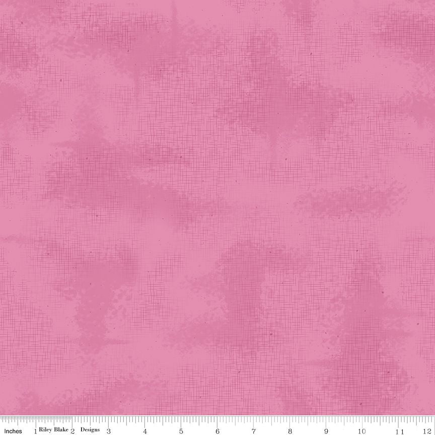 Pink fabric with a subtle textured watercolor pattern and a white ruler at the bottom indicating scale.