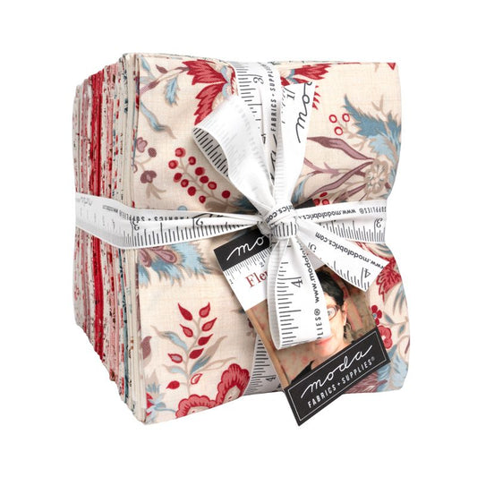 Pack of fabric strips with floral patterns and a measuring tape, tied with ribbon, on a white background.