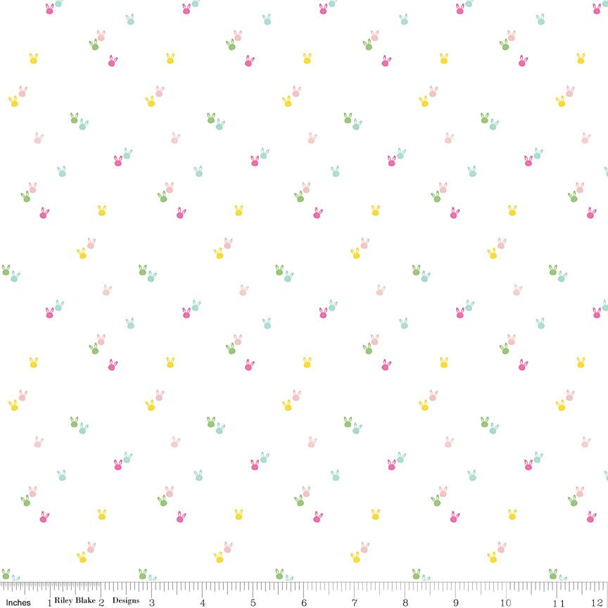 A repeating pattern of tiny pastel bunny silhouettes in pink, yellow, green, and blue on a white background, with a ruler along the bottom edge showing scale.
