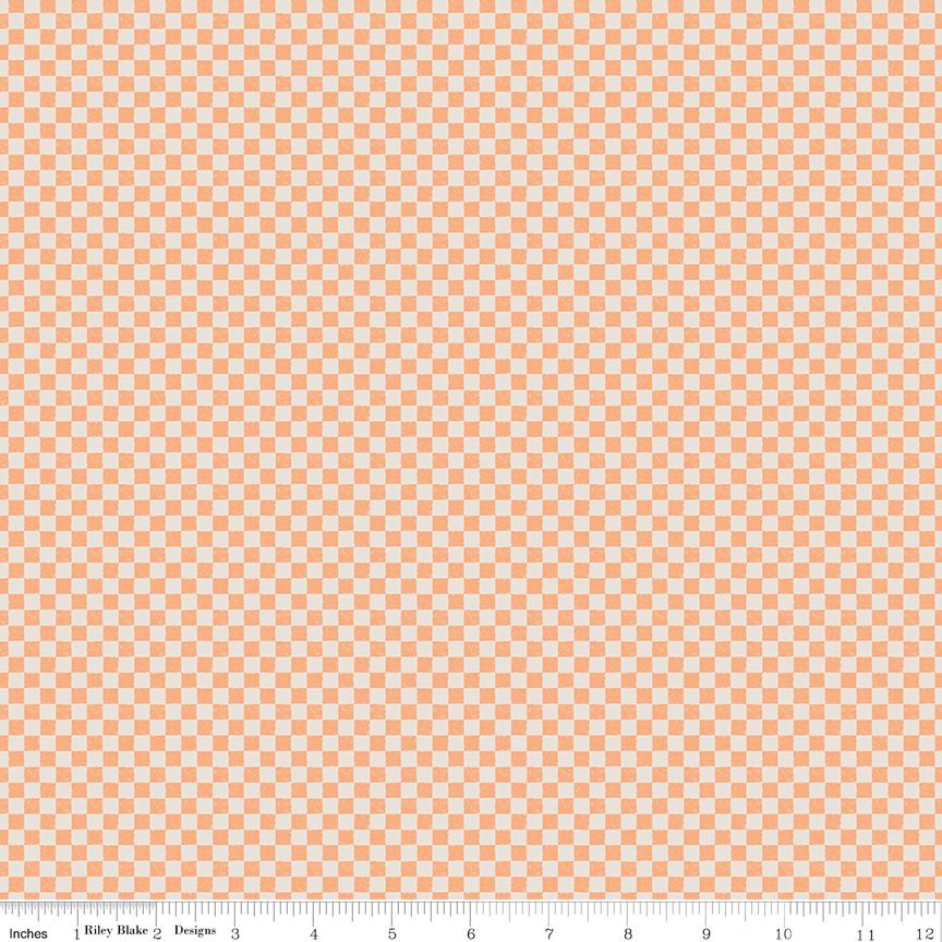 A close-up of a repeating checkerboard pattern in light peach and white, with a measuring ruler along the bottom edge showing scale.