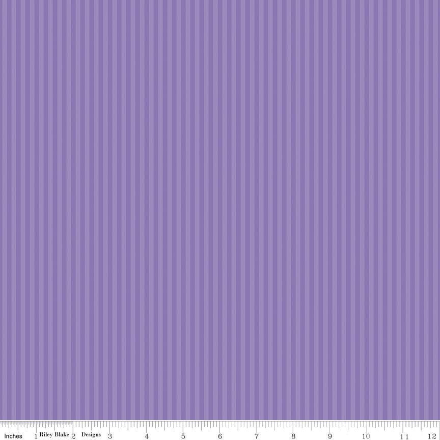 A close-up of a purple striped fabric pattern with alternating vertical stripes of medium and light purple, shown with a measurement ruler along the bottom edge.