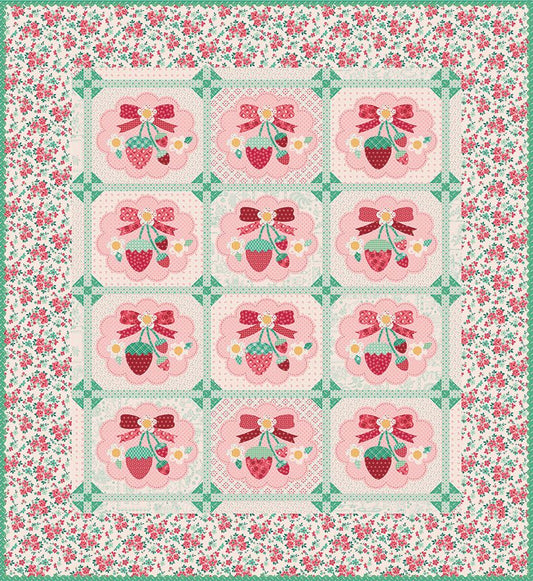 A square quilt featuring a grid of 12 floral medallions with strawberries, bows, and small flowers, surrounded by a green and pink floral border.