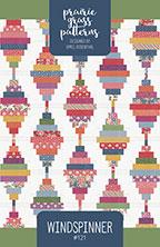 A square book cover for 'Prairie Grass Patterns: Windspinner' featuring a colorful geometric pattern of hanging ornaments on a white background with green side borders.