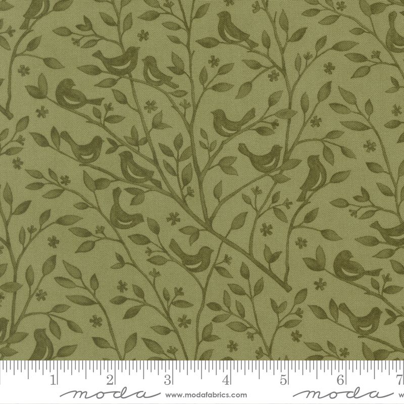Olive green fabric with a repeating pattern of small birds perched on leafy branches and tiny flowers, shown with a measuring ruler along the bottom edge.