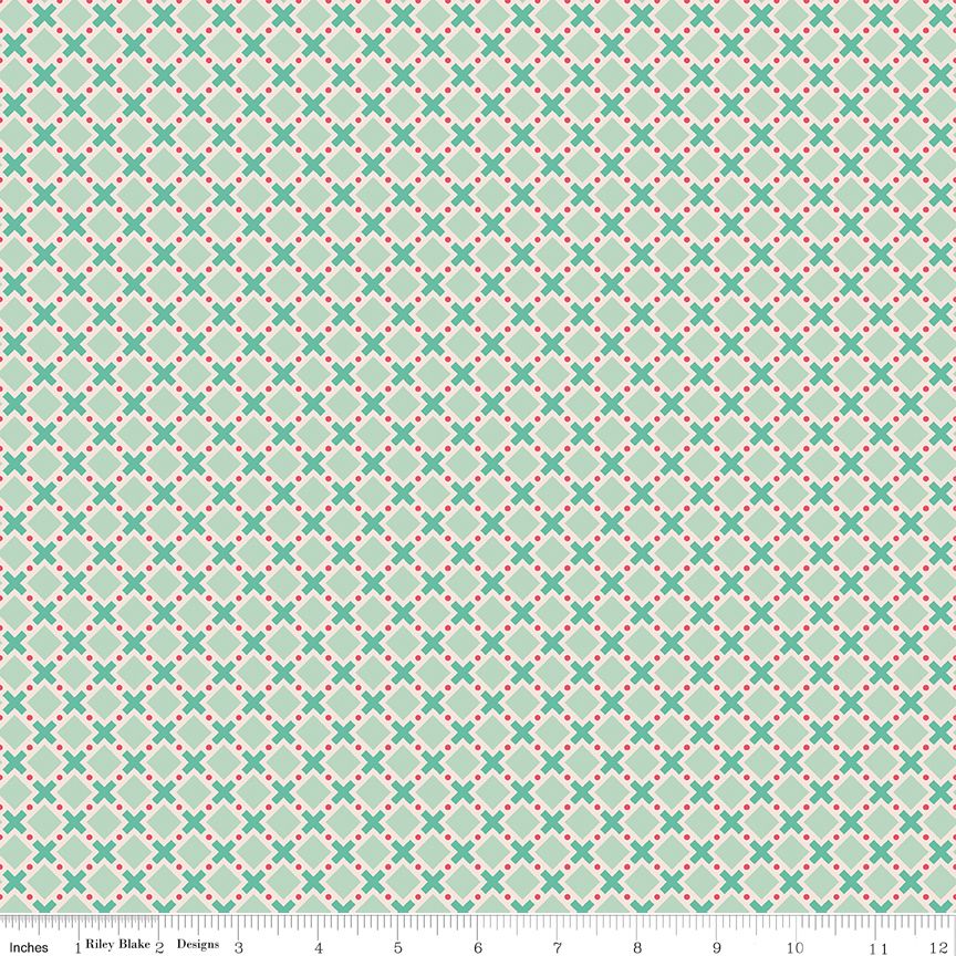 Fabric with green X's and small pink polka dots on a light green background