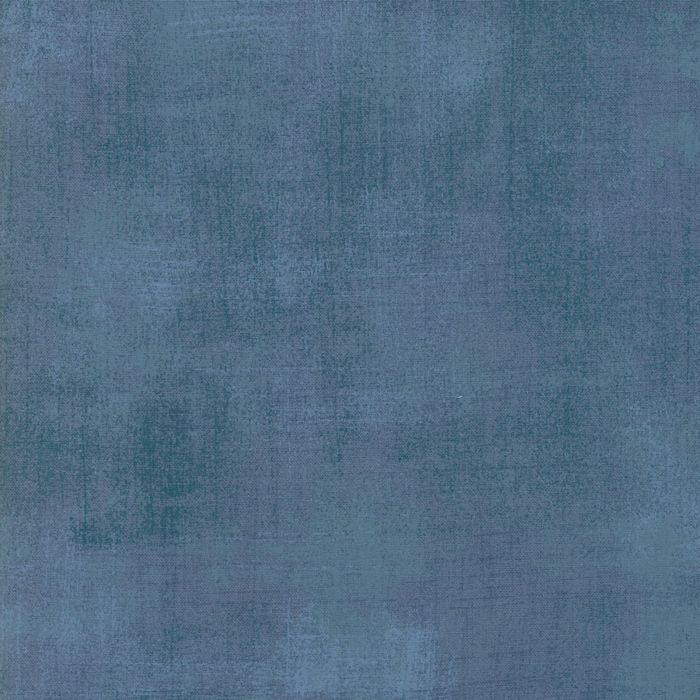 A close-up of a textured fabric or material swatch in a muted slate blue color.
