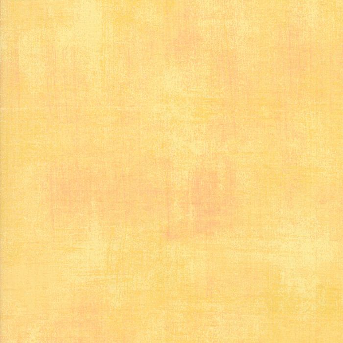 A square swatch of textured fabric in a soft, warm pastel yellow with subtle peach undertones.