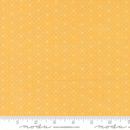 Yellow fabric with a small white geometric pattern, shown with a ruler at the bottom to indicate scale. The brand name 'Moda Fabrics' is visible at the bottom.